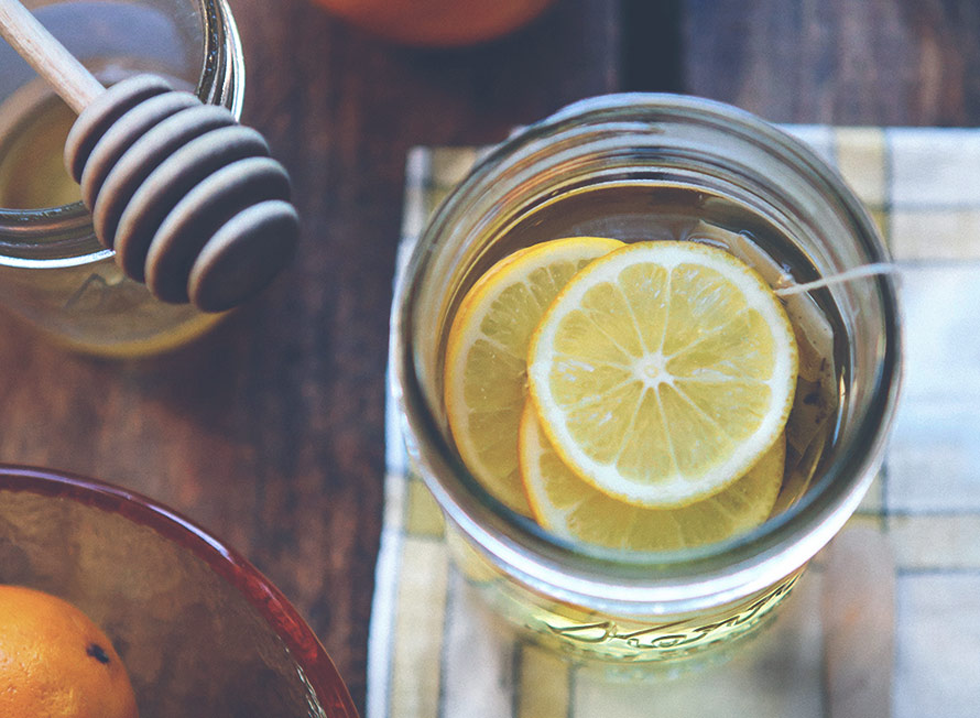 Huskur mot förkylning med citron, ingefära och vatten i ett glas